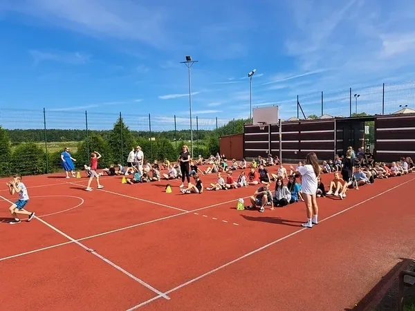 Dzieci i wychowawcy podczas wspólnej zabawy sportowej na boisku