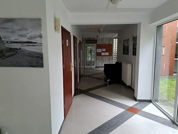 Wejście do budynku i przeszklony hol ośrodka wypoczynkowego