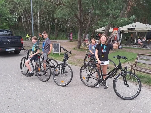 Uczestnicy wycieczki rowerowej przy leśnej drodze