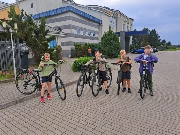 Dzieci z rowerami przed ośrodkiem podczas kolonijnej wycieczki