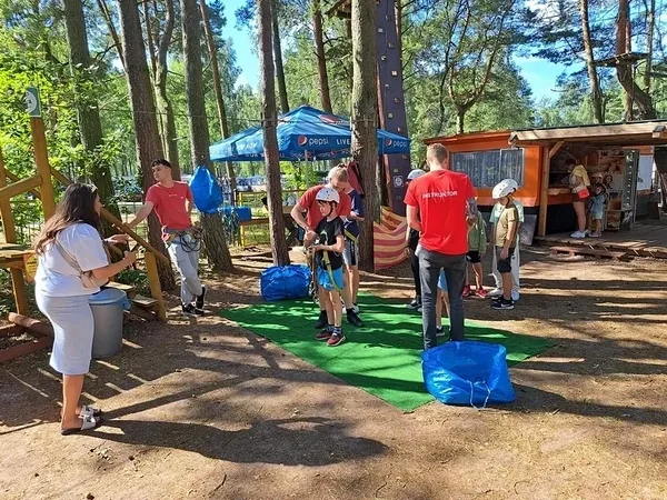 Uczestnicy wycieczki przy stanowisku przygotowania do zabawy w parku linowym