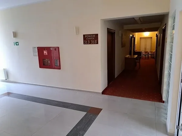 Wewnętrzny korytarz ośrodka wypoczynkowego z oznaczeniami przeciwpożarowymi