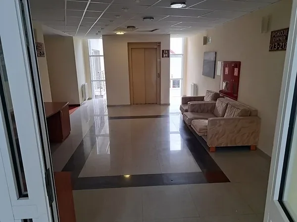 Korytarz ośrodka z miejscami do siedzenia i drzwiami do pomieszczeń