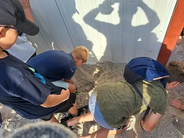 Dzieci oglądają znalezisko podczas zabawy w poszukiwanie skarbów