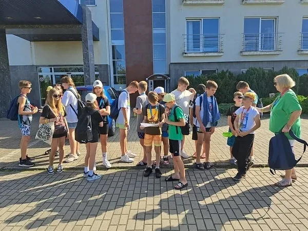 Grupa dzieci gotowa do wyjścia na kolonijną zabawę w terenie