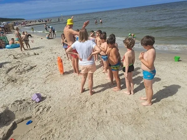 Dzieci bawią się na plaży obok brzegu morza