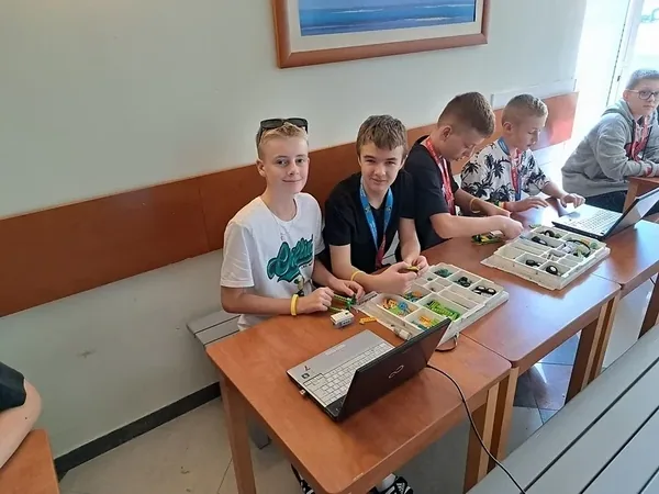 Koloniści wybierają elementy z pudełek zestawów konstrukcyjnych