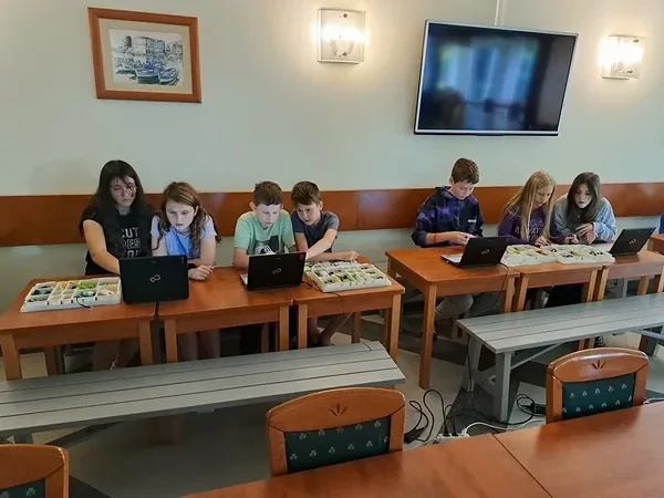 Dziewczęta przy laptopie i elementach do budowy robotów