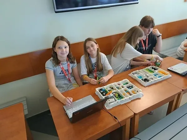 Dzieci z zestawem klocków i laptopem podczas zajęć edukacyjnych