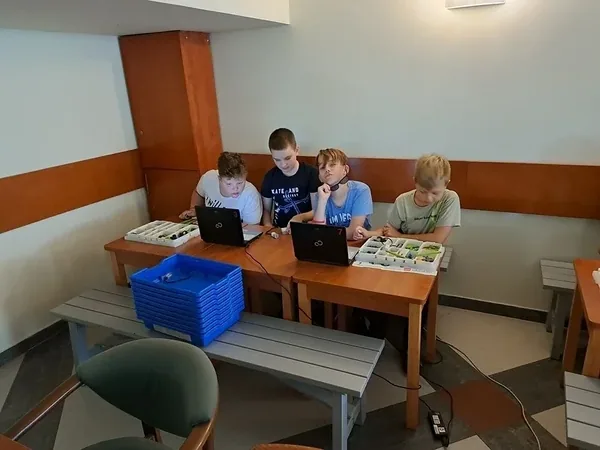 Praca dzieci z laptopem i zestawem konstrukcyjnym podczas kolonii